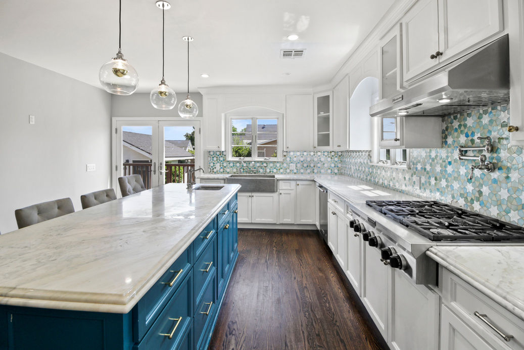 a kitchen with white cabinets and blue counter tops